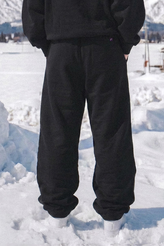 Person wearing black pants standing in a snowy landscape