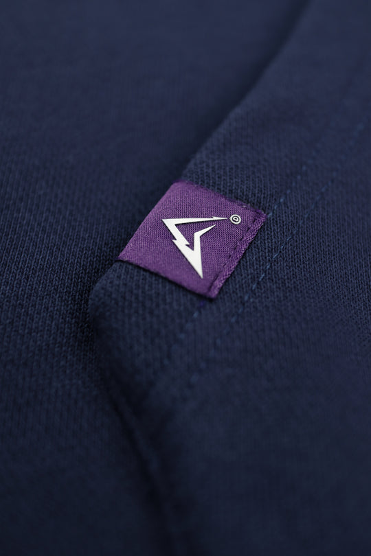 Navy blue fabric with a purple label featuring a white logo.