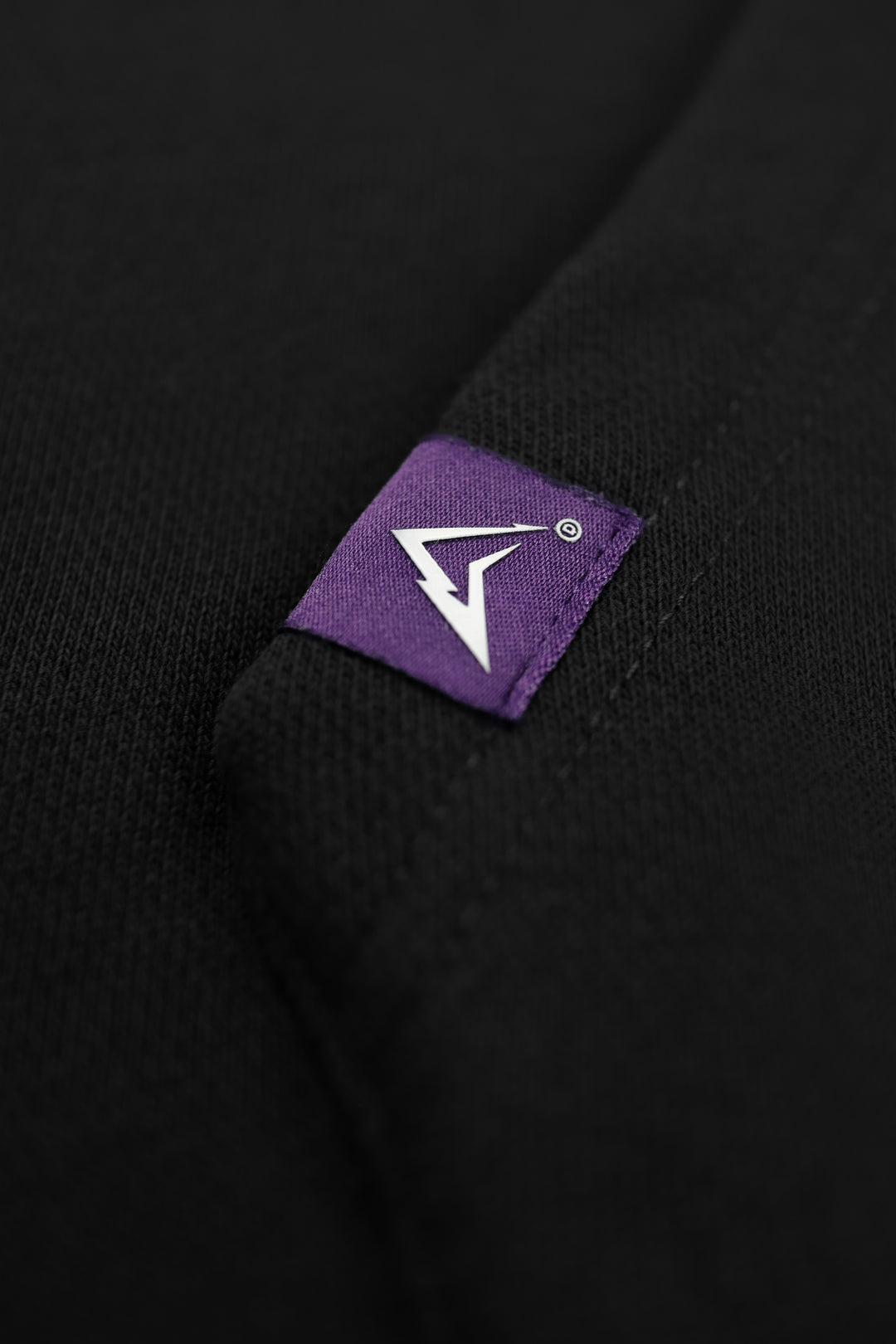 Black fabric with a purple label featuring a white logo