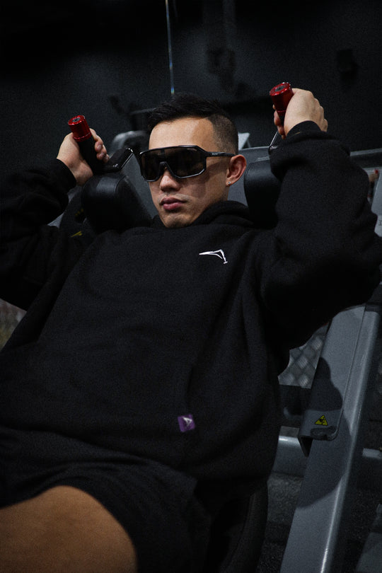 Aurora Divinia Divine Black Hoodie — oversized black hoodie with white Aurora Divinia logo on chest, Act 1.0 collection. At the Gym.